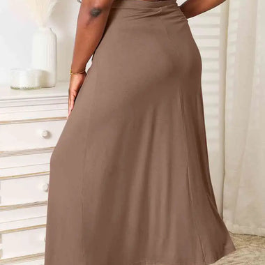 a woman in a white shirt and brown skirt