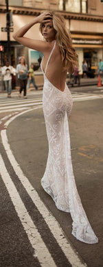 a woman in a white dress standing in the middle of a street