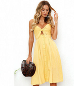 a woman in a yellow dress holding a purse