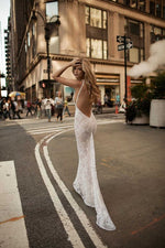 a woman in a white dress standing in the middle of a street