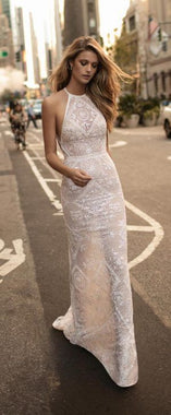 a woman in a white dress is standing on the street