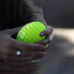 a person holding a green ball in their hands