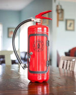 a red fire extinguisher sitting on top of a wooden table