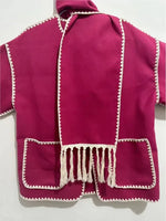 a pink clergy robe with white trim and fringes