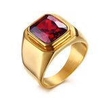 a gold ring with a red stone in it