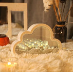 a white cloud shaped mirror sitting on top of a white rug