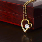 a necklace with a heart shaped diamond on a wooden box