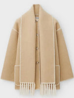 a beige coat with fringes and buttons