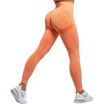 a woman in orange leggings and sports bra