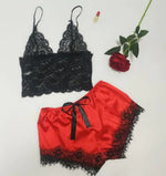 a red and black lingerie and a rose on a white background