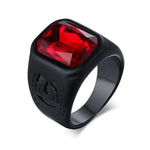 a black ring with a red stone in the center