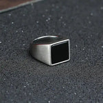 a silver ring sitting on top of a black surface