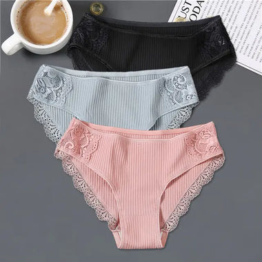 three women's panties with laces and a cup of coffee