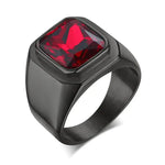 a black ring with a red stone in it