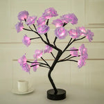 a small tree with pink flowers on a table