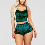 a woman in green velvet shorts and a crop top