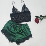 a green and black lingerie next to a rose