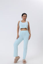 a woman in a light blue crop top and matching pants