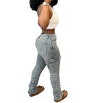 a woman in jeans and a tank top holding a cell phone