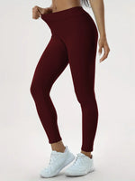 a woman in a red sports bra top and maroon leggings