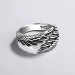 a silver ring with feathers on it