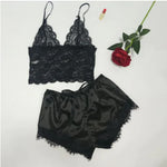 two pieces of black lingerie next to a rose