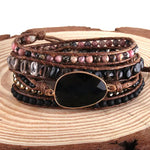 a stack of bracelets with a black stone