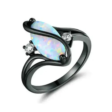 a white opal and diamond ring on a black background