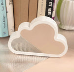 a white cloud shaped mirror sitting on top of a table