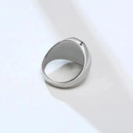 a silver ring sitting on top of a white surface