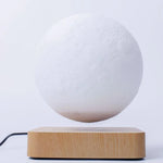 a white ball sitting on top of a wooden stand