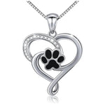 a heart shaped pendant with a dog paw inside of it