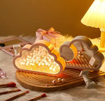 a table topped with a cake shaped like a cloud