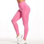 a woman in a pink sports bra top and leggings