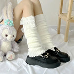 a stuffed bunny sitting next to a pair of black shoes