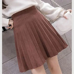 a woman wearing a brown pleated skirt