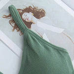 a picture of a woman's green top laying on top of a magazine