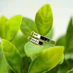 a couple of silver rings sitting on top of a green plant