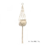 a white hanging planter with beads and tassels