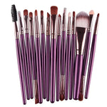 a large set of purple makeup brushes