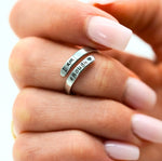 a woman's hand holding a ring with two names on it