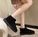 a woman in black boots is sitting on a toilet