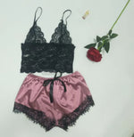 a pink and black lingerie next to a rose