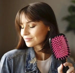 a woman holding a hair brush in her hand