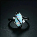 a white opal and diamond ring on a black background